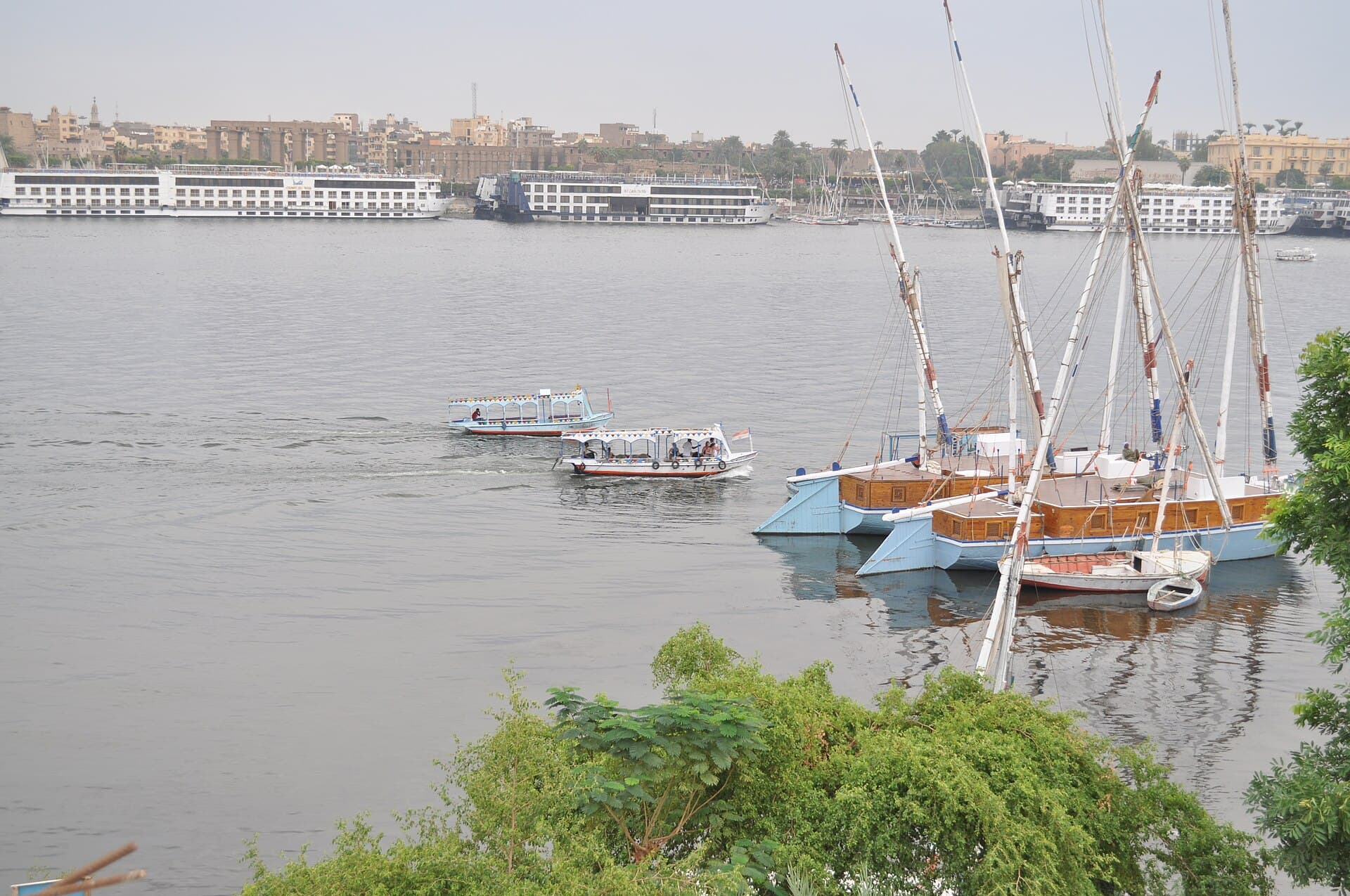 Cruise boats and sailing boats moored on the Nile at Luxor.