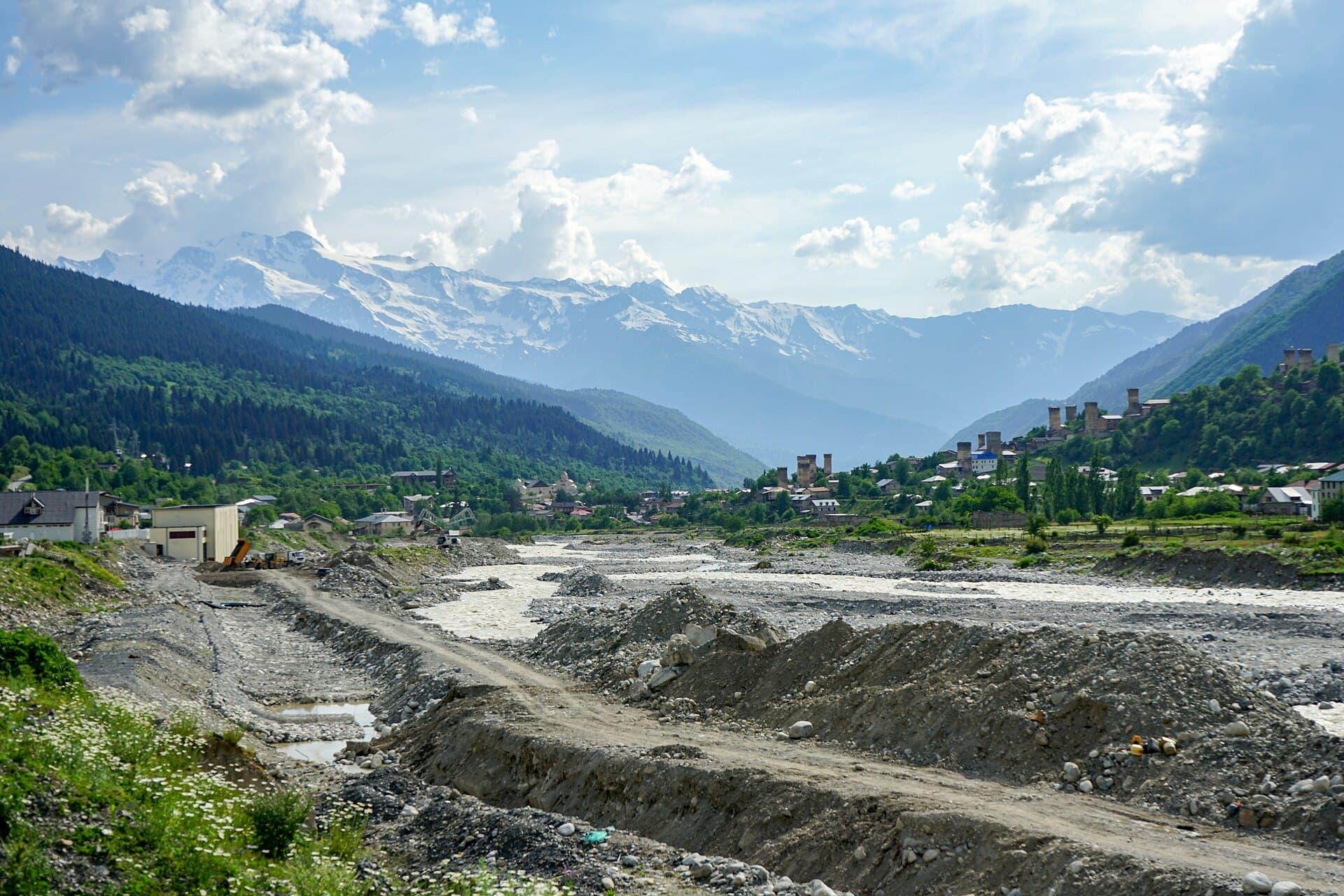 Verschneite Berge Swanetiens von Mestia aus, vorn ein steiniges Flussbett.