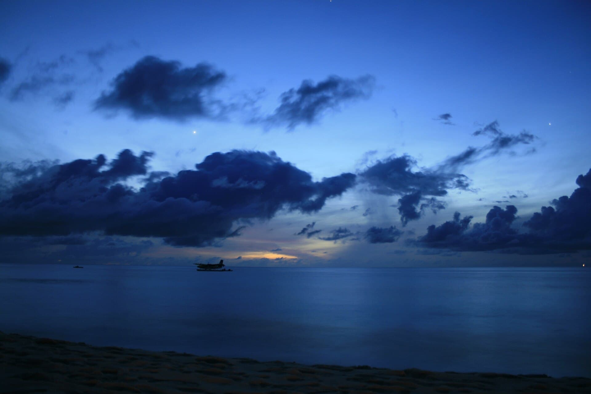 Ein weiterer Strand im Gebiet des Atolls Baa, Palmen am Rand des türkisfarbenen Wassers.