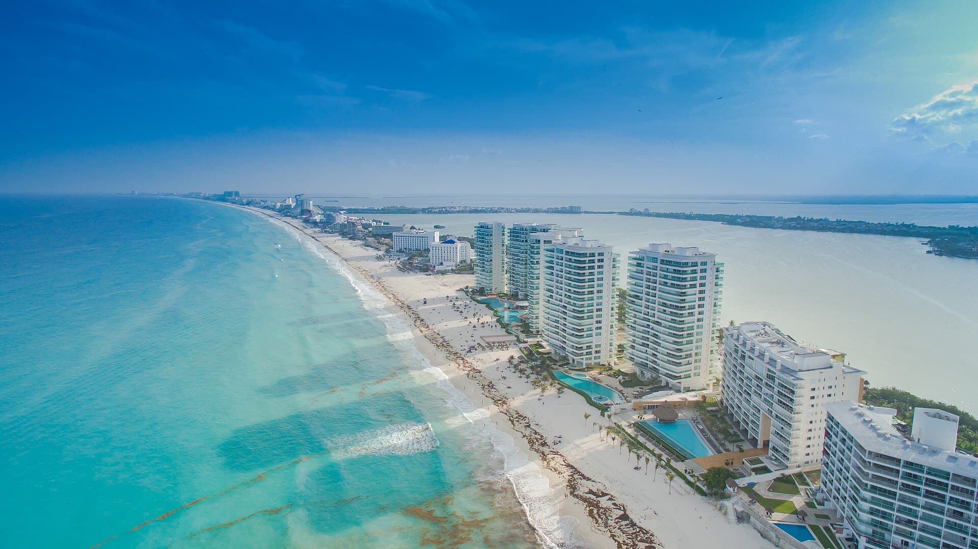 Cancún'ün otel şeridi havadan: bir yanda turkuaz Karayip, öbür yanda lagün.
