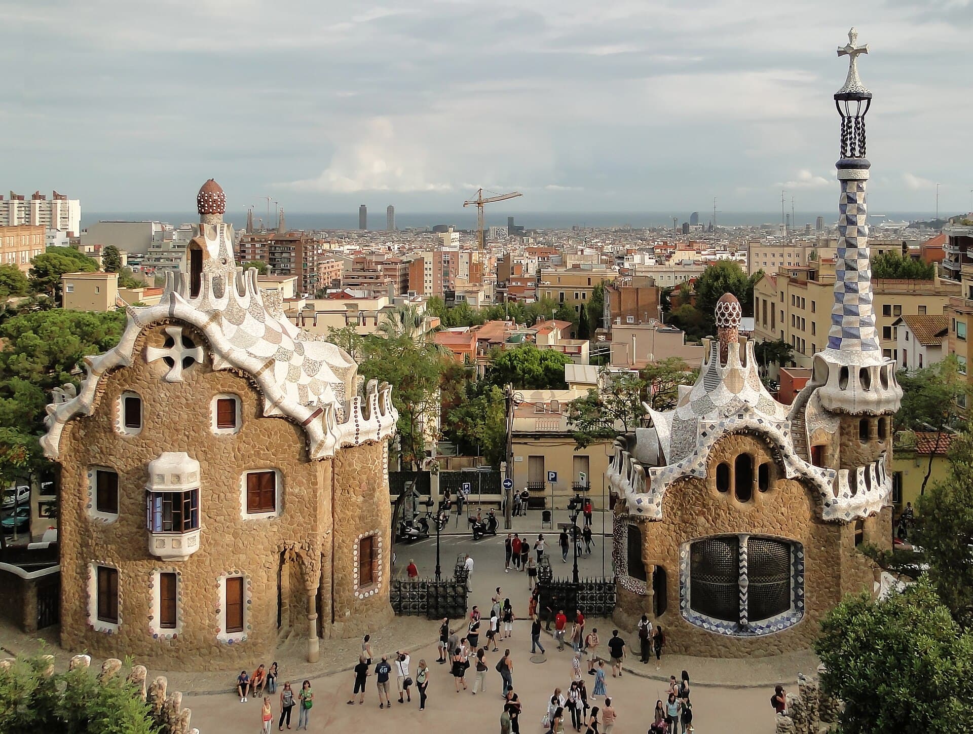 The gate lodges of Park Güell, roofs of broken ceramic, with the city and the sea behind.