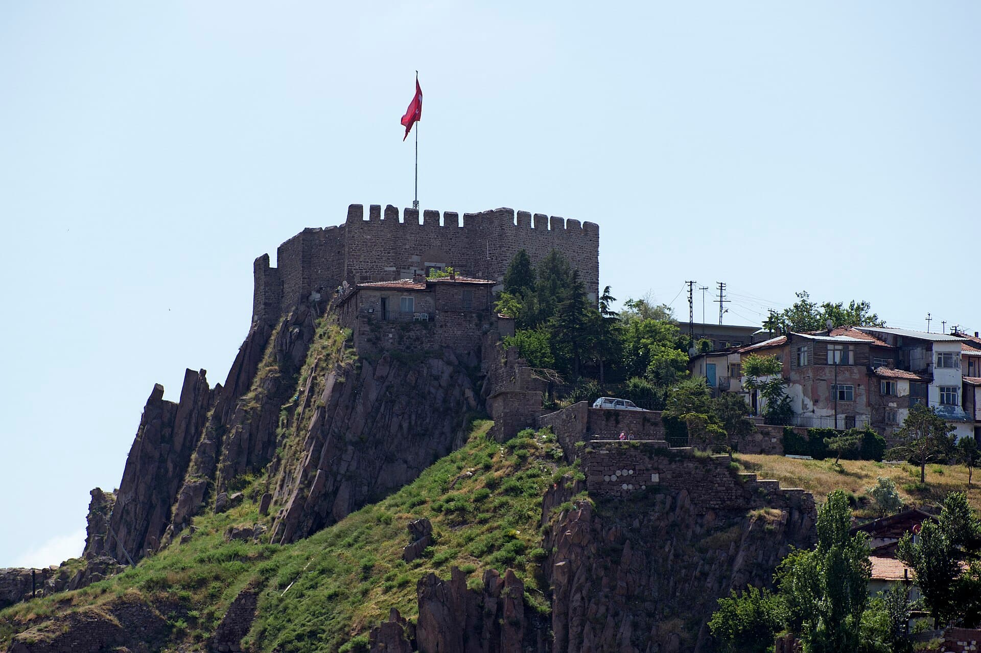 Die Mauern der Burg von Ankara auf einem dunklen, begrünten Felshügel.