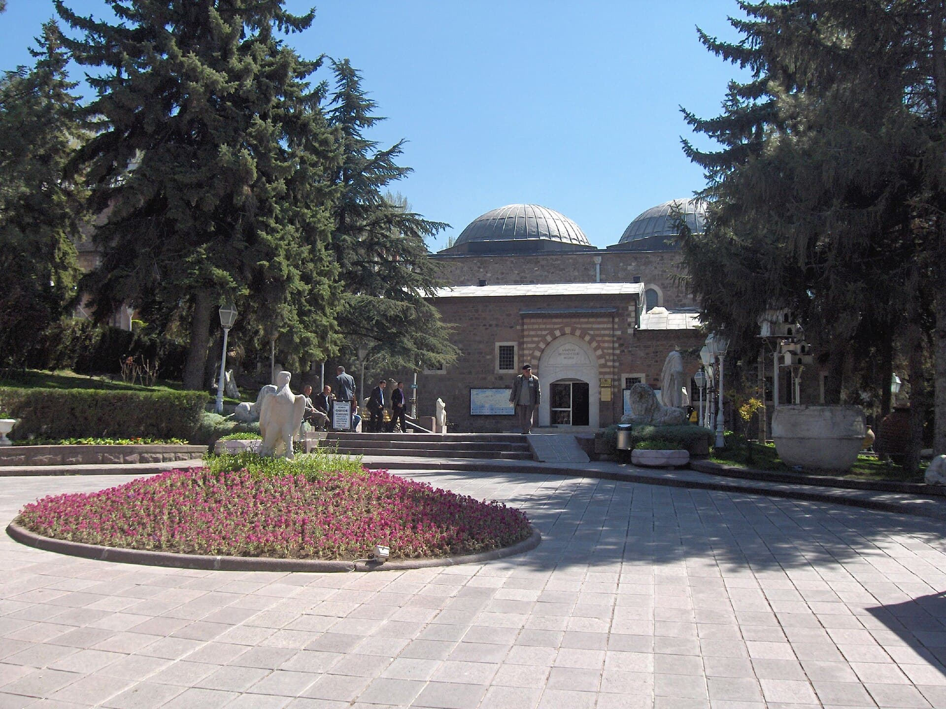 Das überkuppelte Steingebäude des Museums der anatolischen Zivilisationen mit Garten davor.