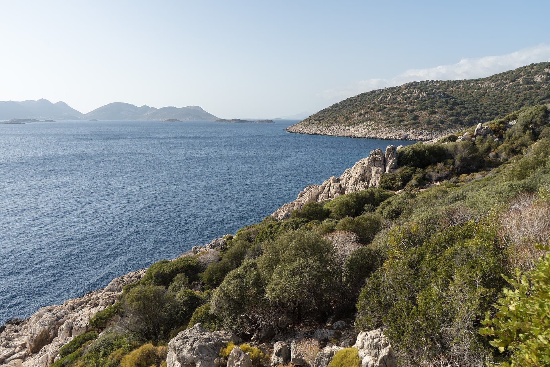 Grüne Felsküste und kleine Inseln im Meer, vom Lykischen Weg bei Kaş aus gesehen.