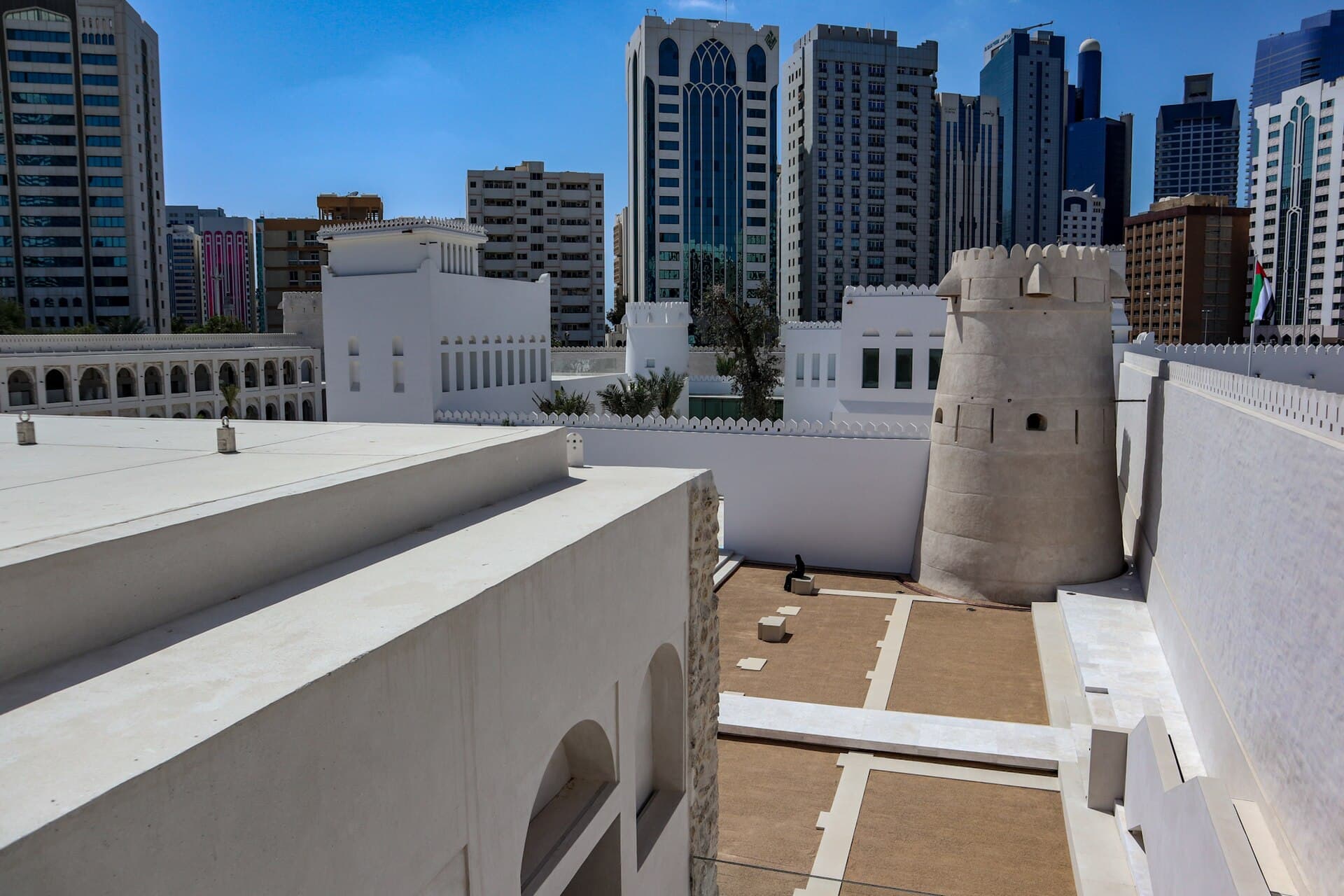 Hof und Rundturm von Qasr al-Hosn zwischen den Hochhäusern im Zentrum von Abu Dhabi.