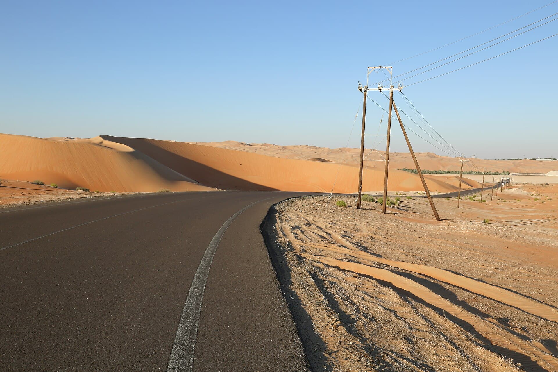كثبان رملية عالية بجانب طريق في صحراء ليوا.
