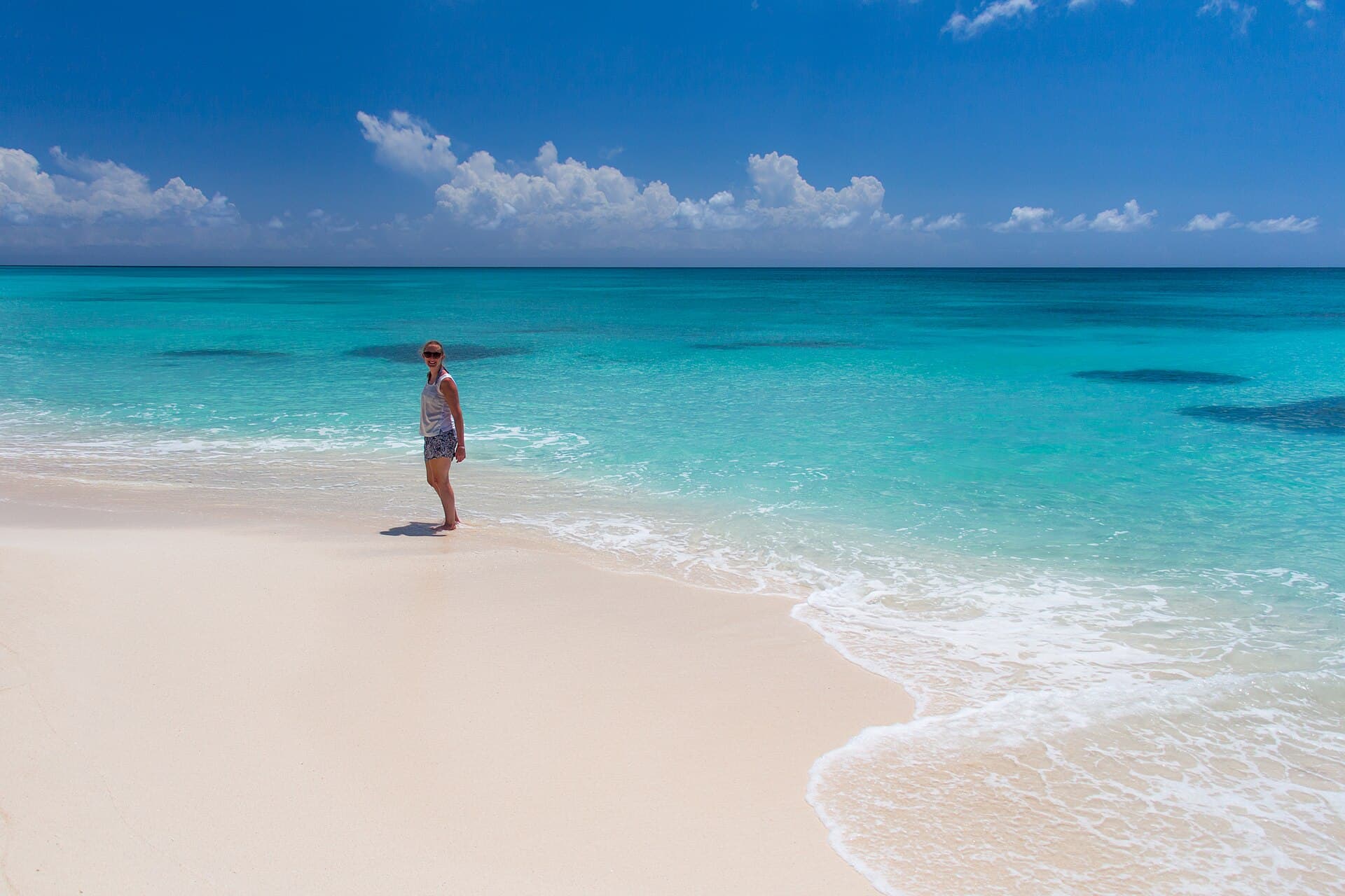 Пляж острова Саона с белым песком и густыми пальмами.