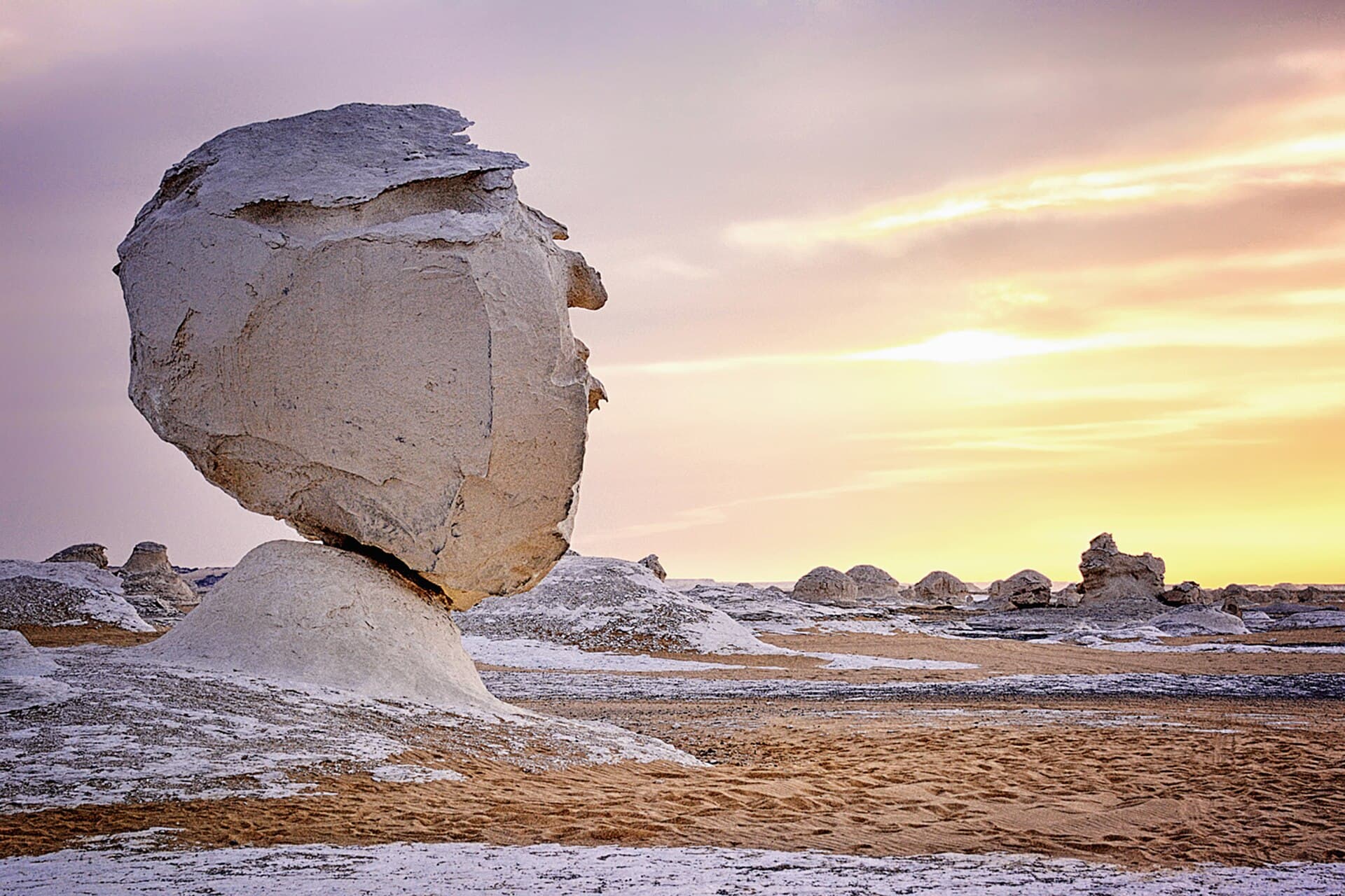 Ein pilzförmiger Kreidefels in der Weißen Wüste bei Sonnenuntergang.