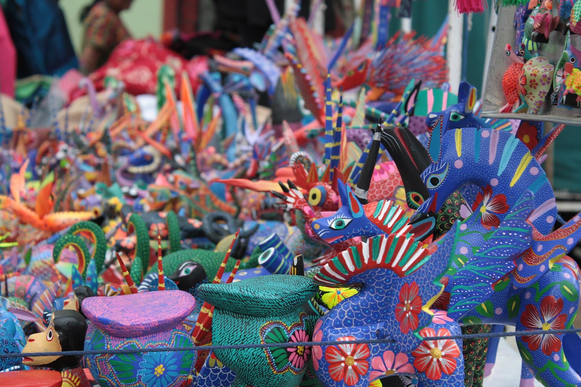 Leuchtend bemalte Holzfiguren fantastischer Tiere mit feinen Mustern in Oaxaca.